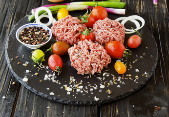 raw minced meat, vegetables with salt and spices, selective focus