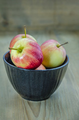 Red and yellow apple with black bowl