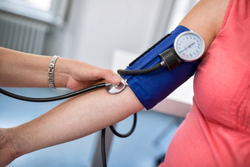 Nurse checking blood pressure of a pregnant woman