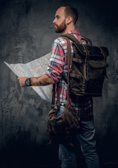 Male with backpack holding city map.
