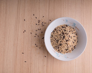 Rice gain in spoon on wood table 