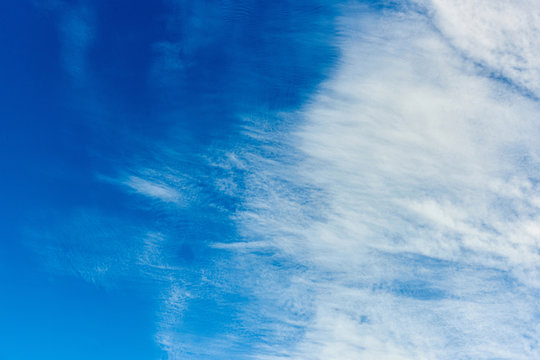 Majestic blue sky background with white scattered clouds by wind
