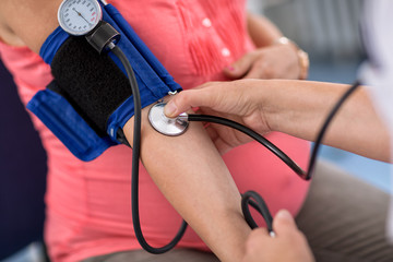 Nurse checking blood pressure of a pregnant woman, close up