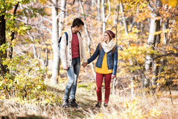 Beautiful couple on a walk in sunny autumn forest