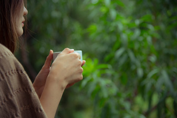 Asian woman holding a cup of coffee