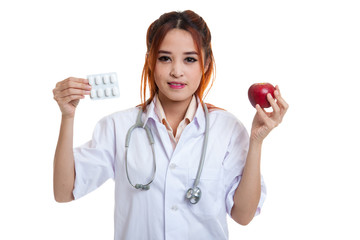 Young Asian female doctor with pills and apple.