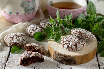 Chocolate-mint cookies and powdered sugar on a wooden background