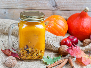 Healthy Breakfast. A smoothie made of pumpkin and apples with granola and nuts in a mason jar. A rustic style. Selective focus
