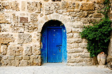 Fototapeta na wymiar The door to the oriental style in the stone wall, Tunisia