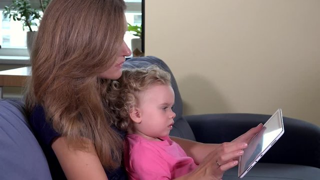 Mother woman teaching toddler girl using tablet computer