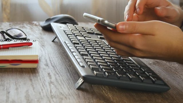 Man working on computer at wooden desk