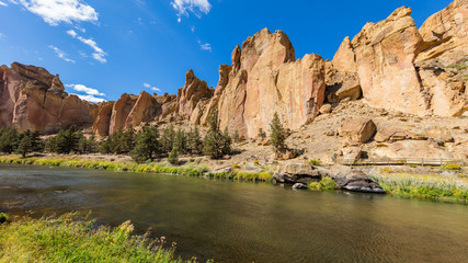 Fototapeta na wymiar River flowing in the valley against the background of sharp rocks. Smith Rock state park, Oregon