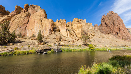 River flowing in the valley against the background of sharp rocks. Smith Rock state park, Oregon