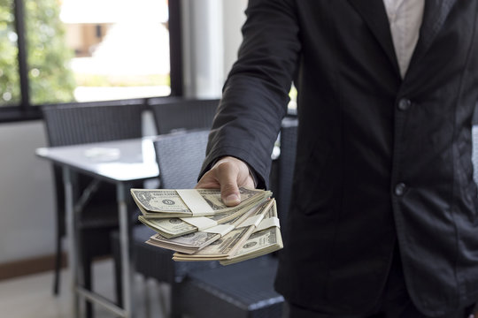 Young businessman sitting at a desk in the office. Counting mone