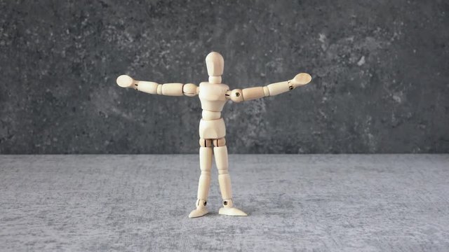 Wooden puppet rising up. Concept film clip of success and victory.