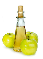 apple cider vinegar in a glass vessel and green apples