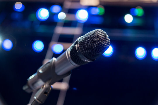 Wireless microphone on stage, blurred lights in the background
