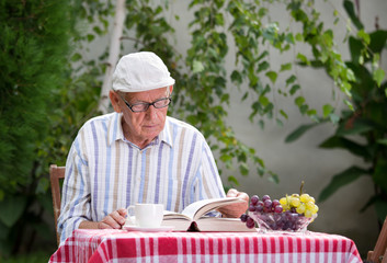 Senior man reading book in garden