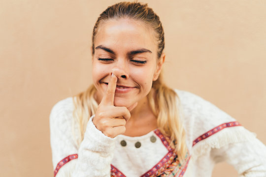 Funny woman picking her nose with finger