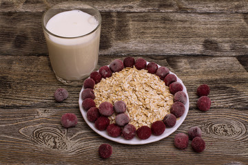 oatmeal with cherries and a glass of milk on a wooden table