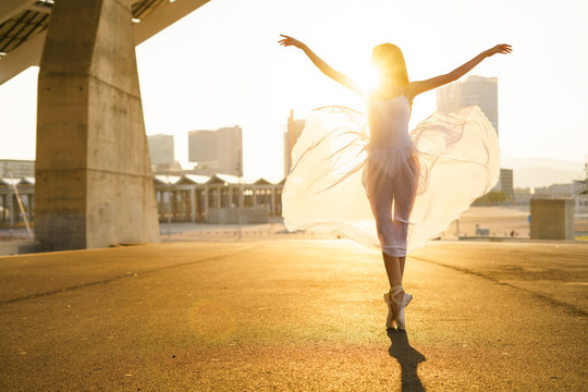 Ballet dancer performing ballet on the street during sunrise