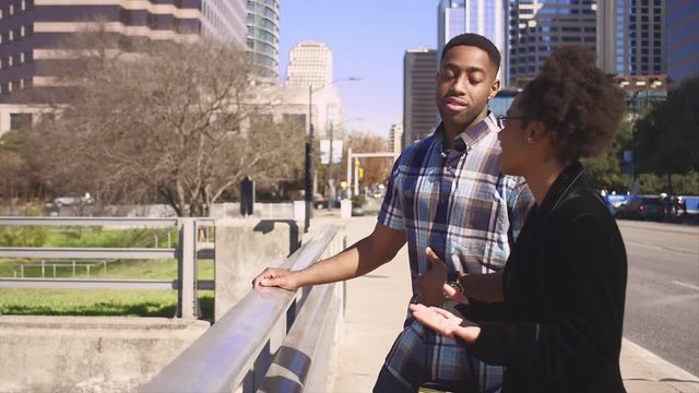 African American couple talking at a waterfront in a city