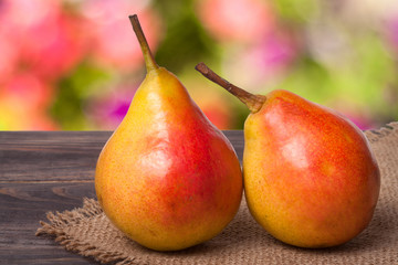 two pears on a dark wooden table with  blurred background