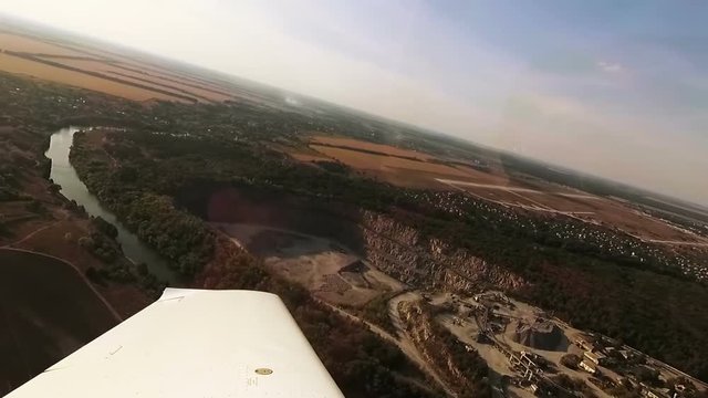 Flying over a quarry. View from cockpit of small airplane.