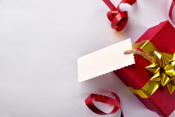 Red gift box with golden ribbon and label hanging
