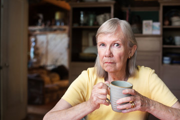 Angry mature woman holding cup