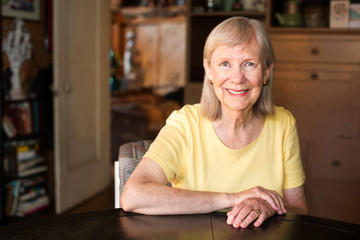 Confident mature woman seated at table