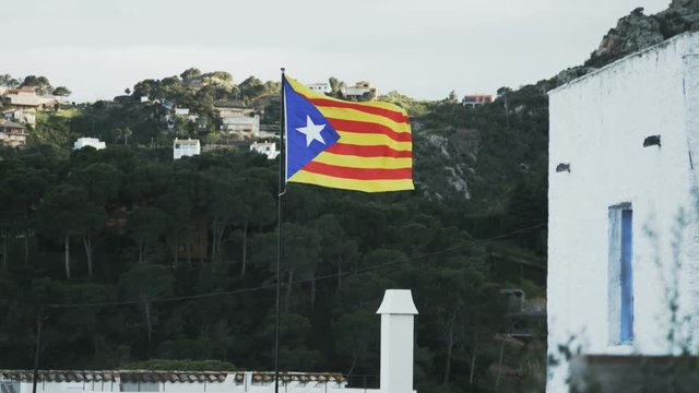 Catalunya flag. Hills and a house in the surrounding.