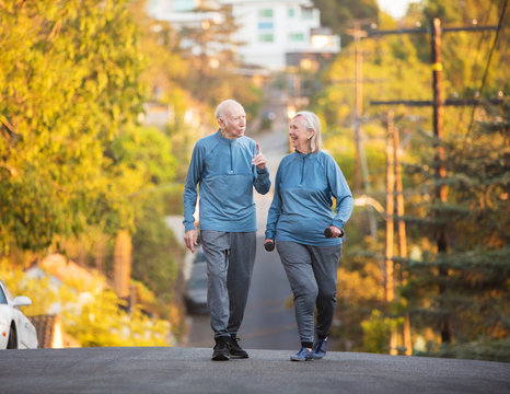 Senior couple walking along street on hill