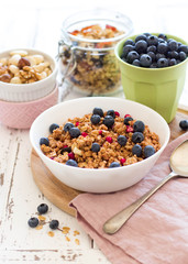 Healthy breakfast; Homemade granola with blueberries and nuts in white bowl