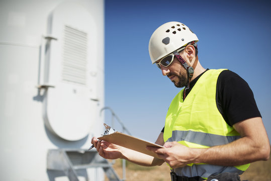 Energy engineer reading clipboard at construction site