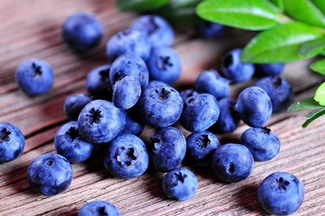 Ripe organic blueberries on the old wooden background.
