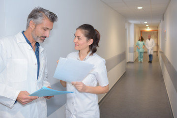Doctors looking at notes in hospital corridor