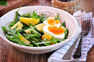 Vegetable salad with green beans, potatoes, arugula, eggs and olive oil. Vintage style.