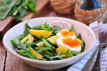 Vegetable salad with green beans, potatoes, arugula, eggs and olive oil. Vintage style.