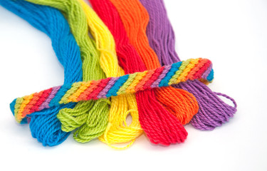 Colorful yarn for making wristbands for children, with one ready made shown