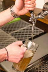 Beer tap. Hands of a bartender pouring beer from tap