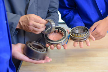 Bearings held in the hands of three people