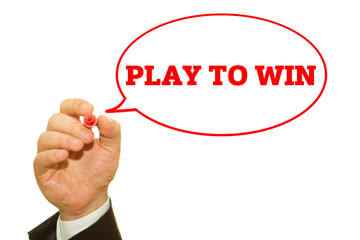Businessman hand writing PLAY TO WIN message on a transparent wipe board.