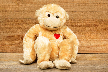 Toy monkey on a wooden background