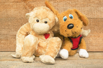 Children's toys on wooden background. Funny dog and funny monkey