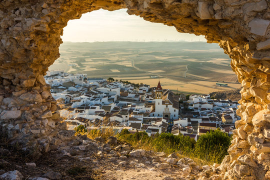Andalusian white village through a hole on the wall at sunset (Teba, Spain)