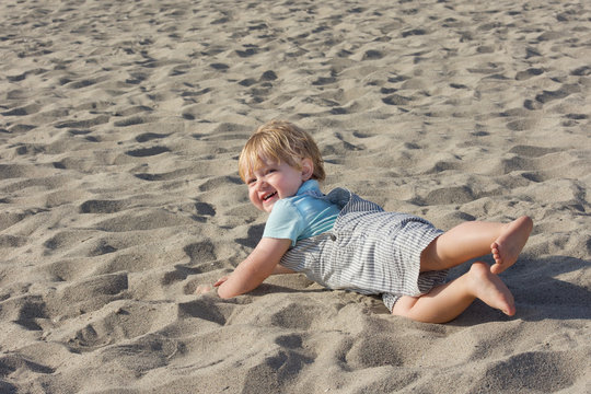Young Toddler Boy Falling Over In The Sand