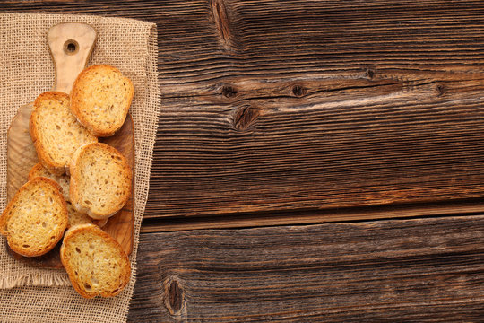 Grilled toasts on old wooden background and space for text