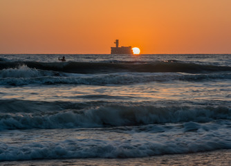 the sun rises over the horizon of the sea and the boy enjoys the rising sun