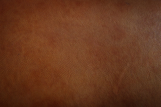 Dark brown leather texture closeup can be used as background.